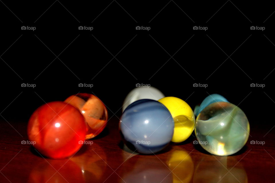 Brightly colored marbles on a table with black background 