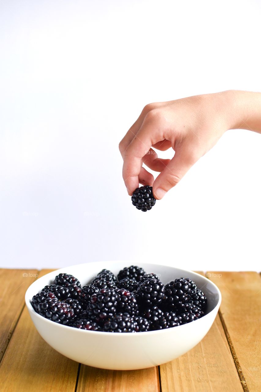 Hand picking a blackberry from the Bowl