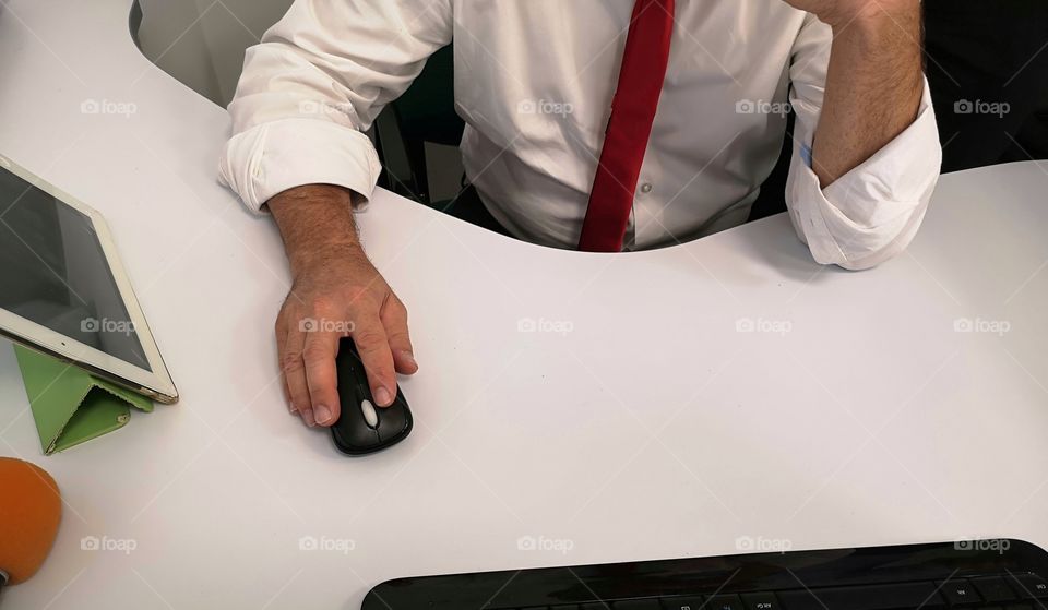 Man in the office uses the computer and the mouse