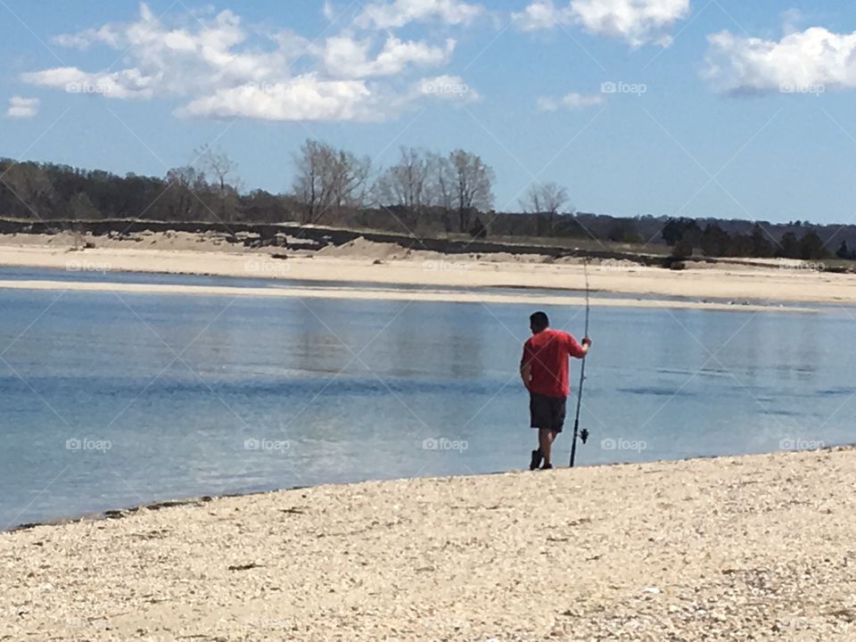 A man fishing on the beautiful beach.