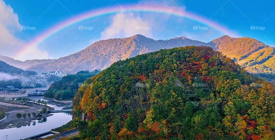 The image embodies a natural natural plate of the mountains of nature, where green agricultural stands are graded on the slopes as if they were lines of a poem, which fog harmoniously wrapped, and clouds hugged them in the mountain knife and the whis