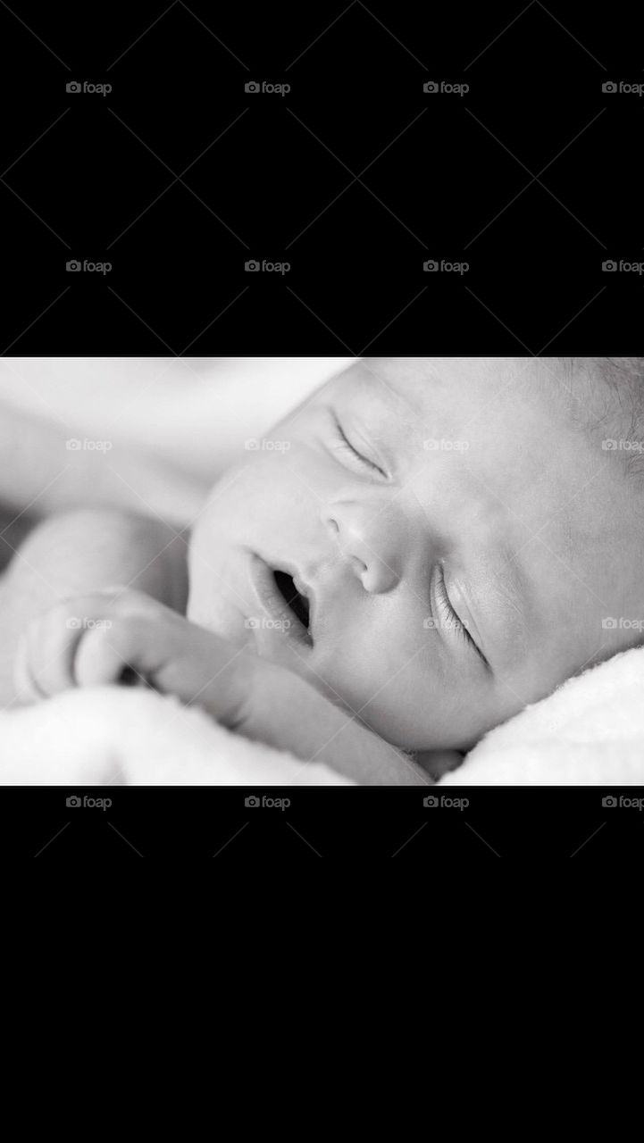Black and white photo of a newborn baby sleeping 