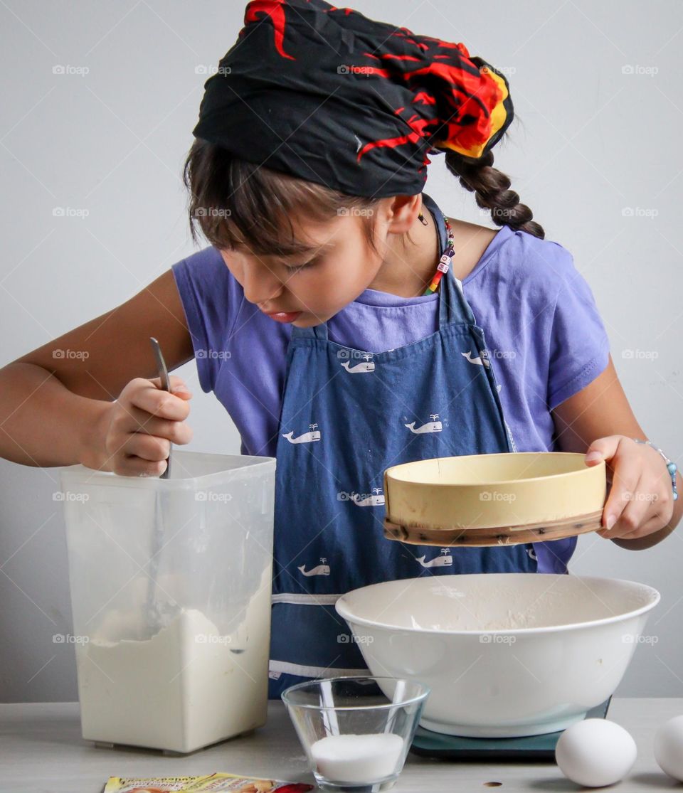 Cute little girl is helping in a kitchen