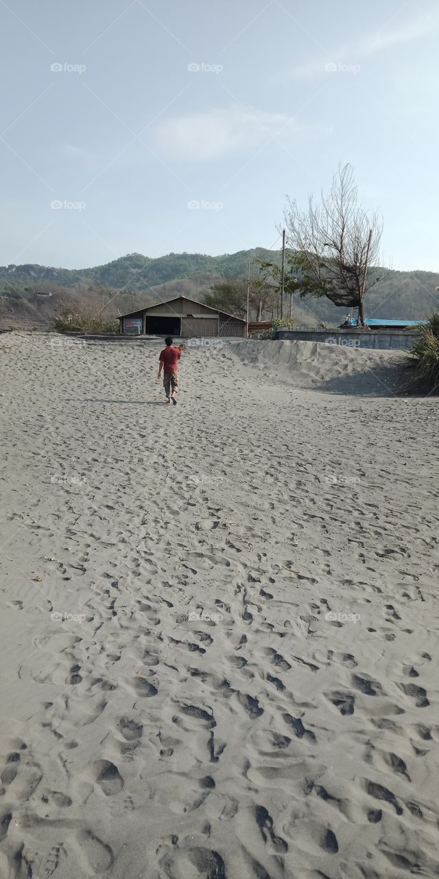 a man walks in the desert of the beach