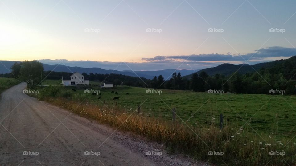 The Sun Sets on the Berkshires in the Distance with a Quaint Farmhouse and Pasture in the foreground