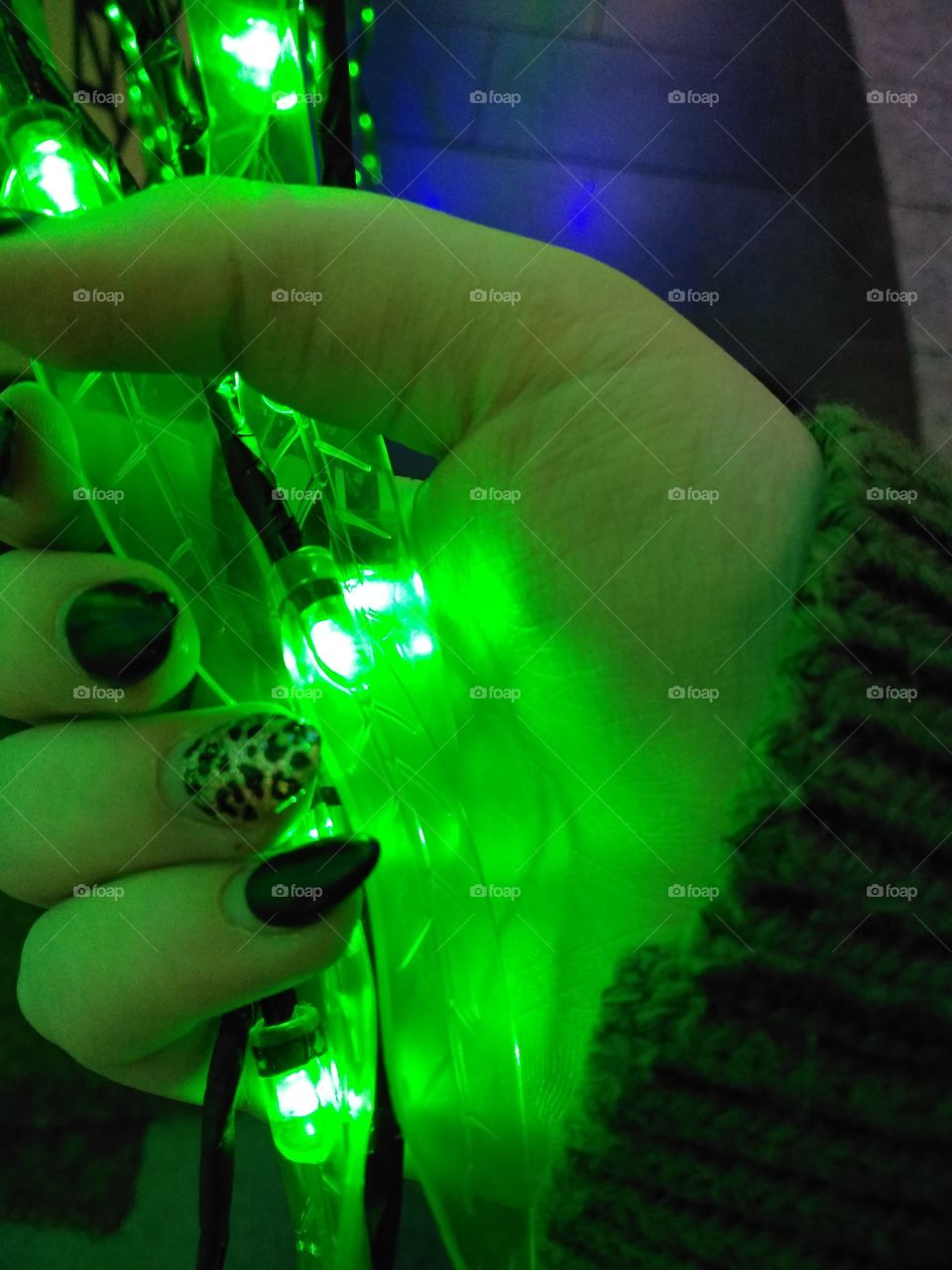 holding strings of leafy, bright, green fairy lights with gel nails at Victoria Square, Belfast