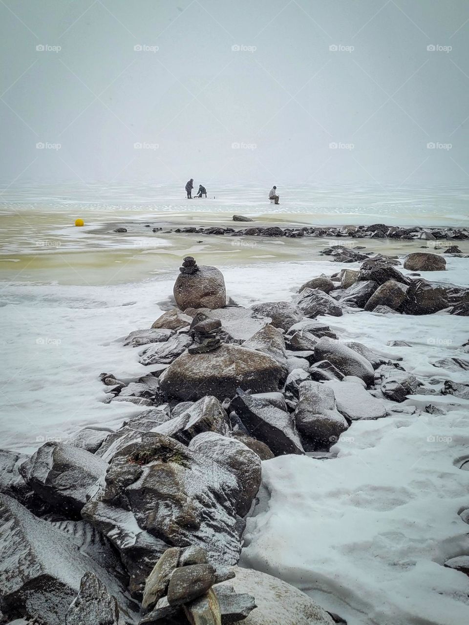 Group of people ice fishing in the distance