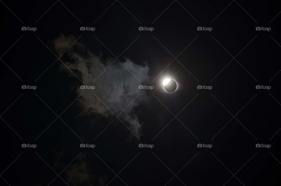 Total diamond solar eclipse in Saint Louis with a cloud crossing its path 