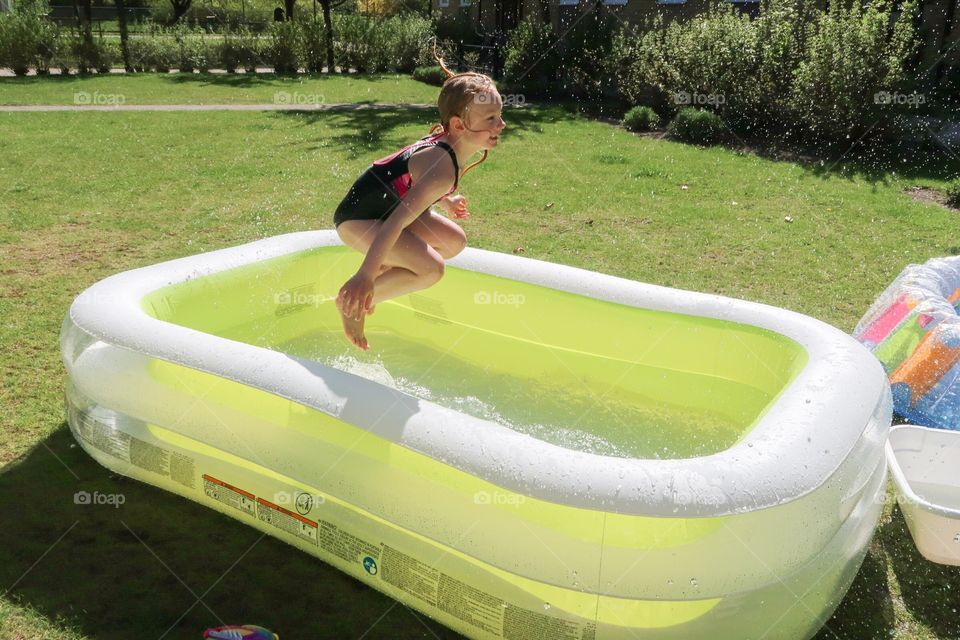 7 year old girl playing in the garden pool