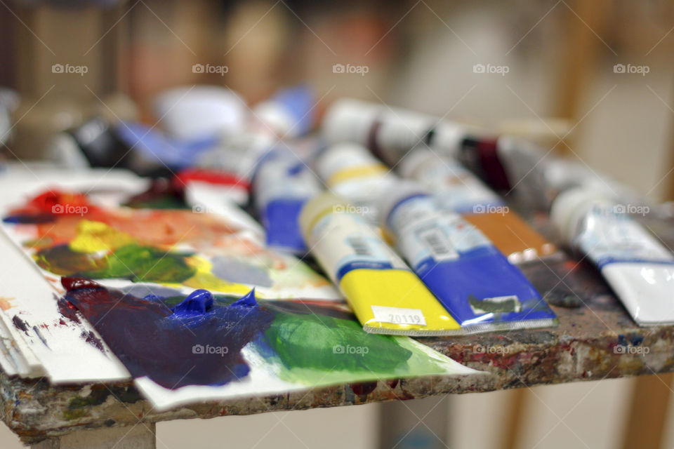 Paints and a palette wait to be used by an artist in the studio