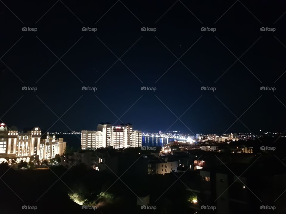 Cityscape in the night near the sea.