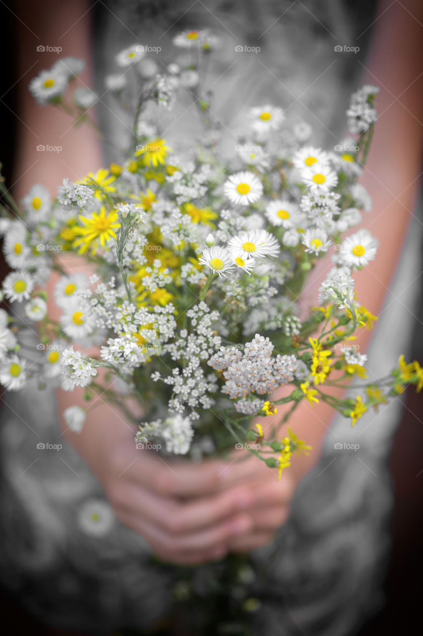 Moods of summer - happiness. Holding bouquet of wildflowers in hands.