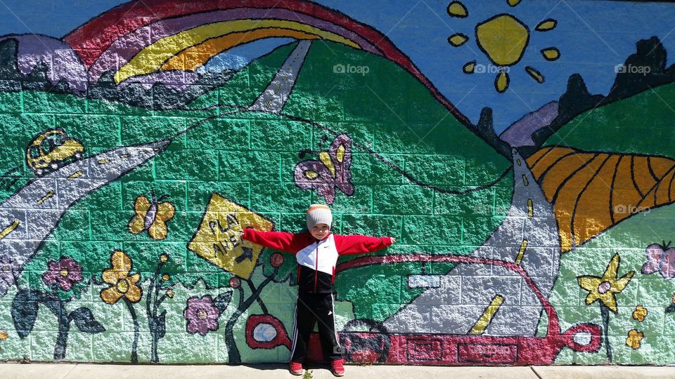 Child leaning on playground mural