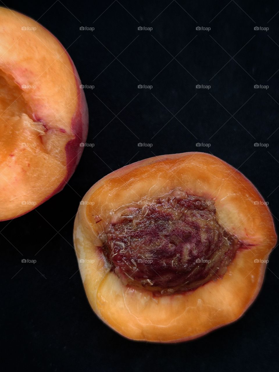 half a peach with a bone on a black background.