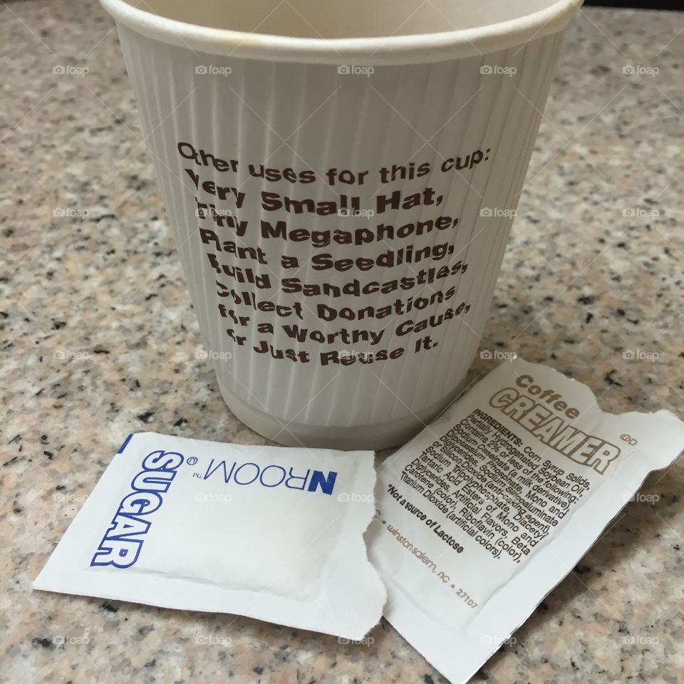 Coffee cup encouraging recycling served with disposable sugar and creamer