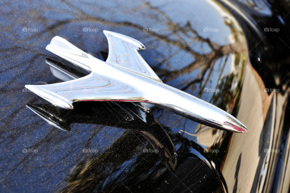 Space aged hood ornament on a classic car.