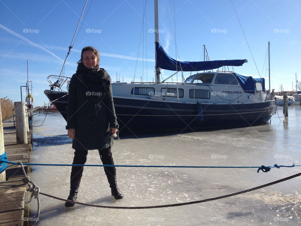 standing on ice with boat