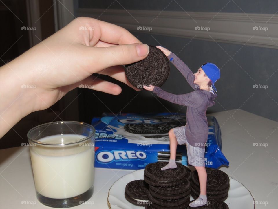 Handing miniature boy Oreo cookie