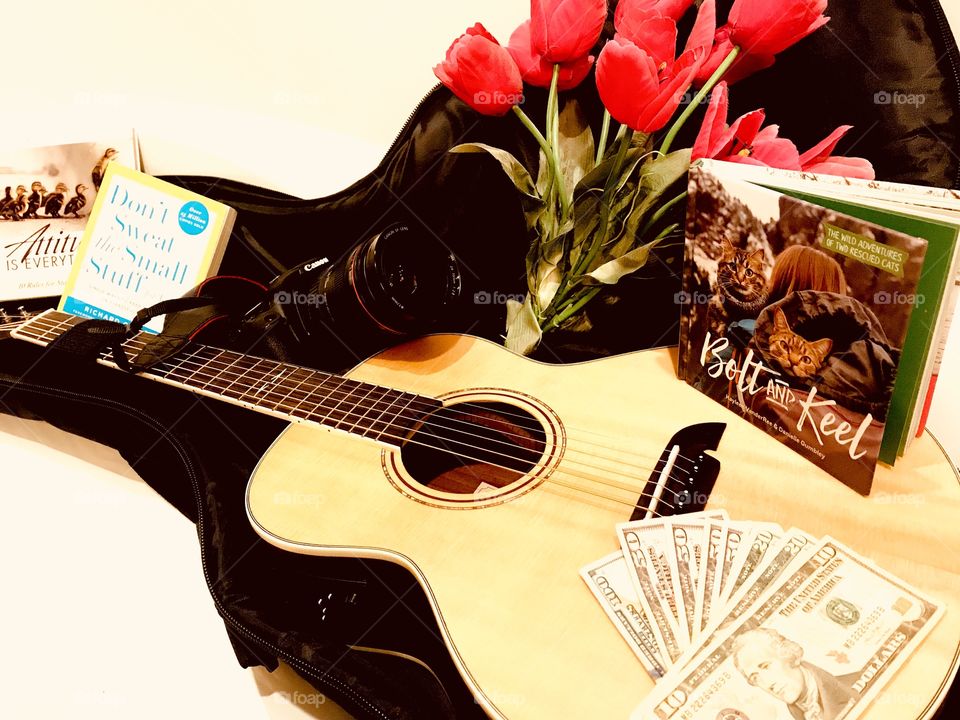 Fun photo of guitar with guitar case filled with books, money, and camera for trip! 