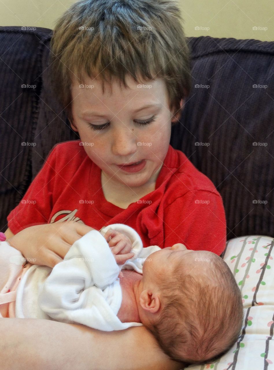 Boy Holding His Newborn Baby Sister