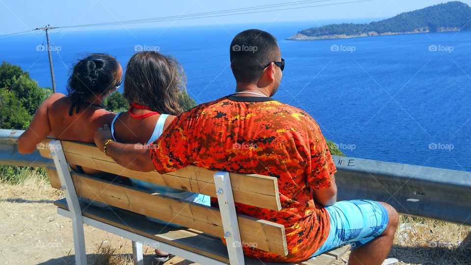 Young family enjoying in the fantastic view of beautiful blue sea