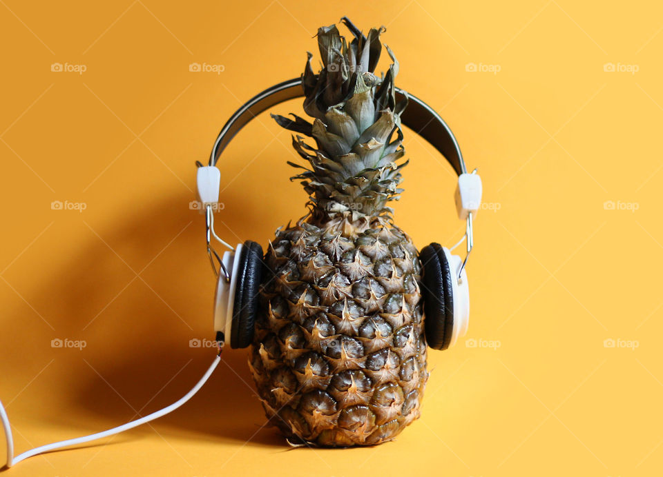 A pineapple listening to music