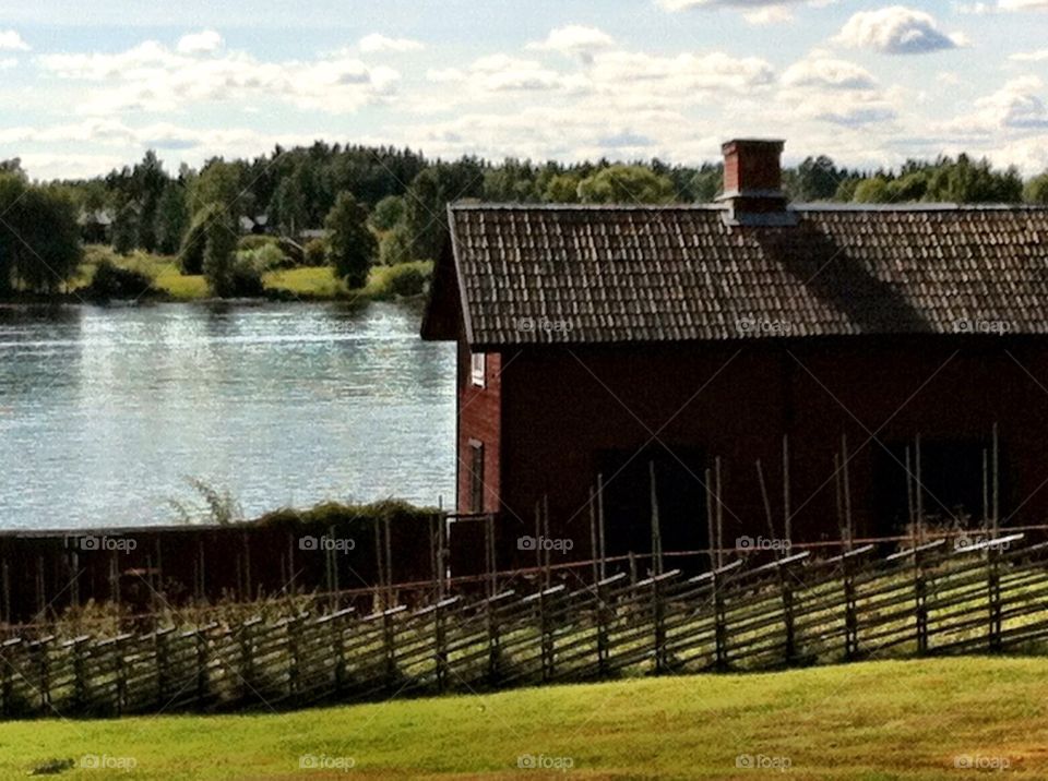 Swedish red wooden house in rural landscape.
