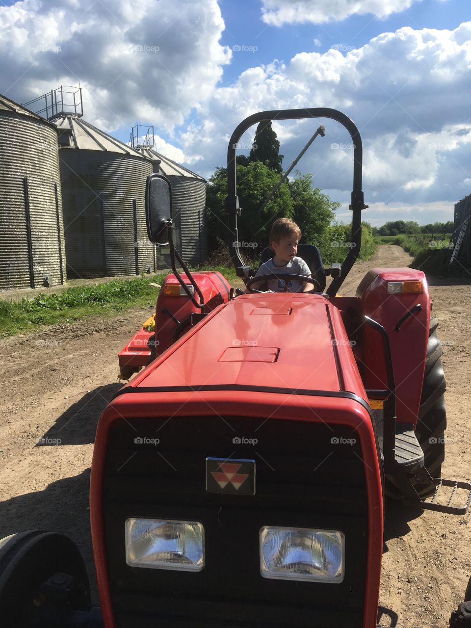 Toddler tries his hand at a bit of tractor driving 