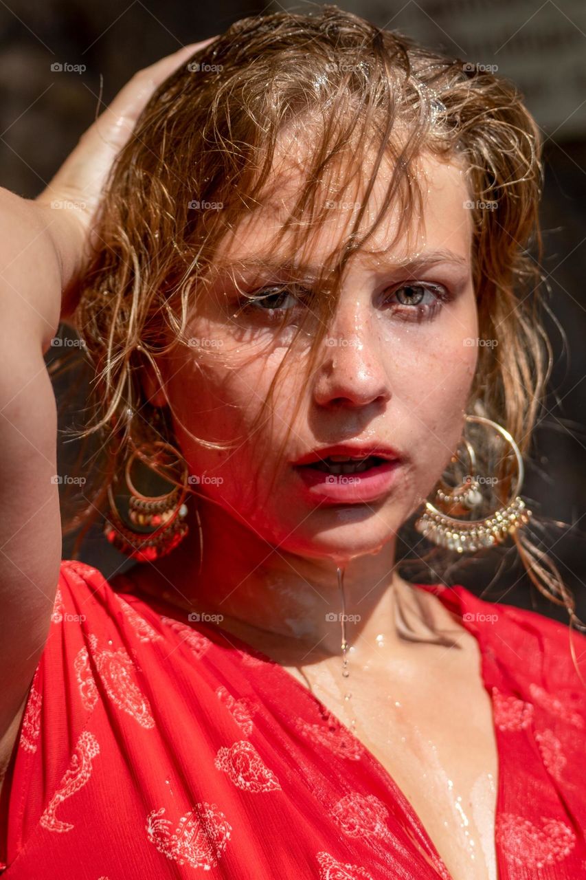 portrait of a young blonde woman with water on her face and hair