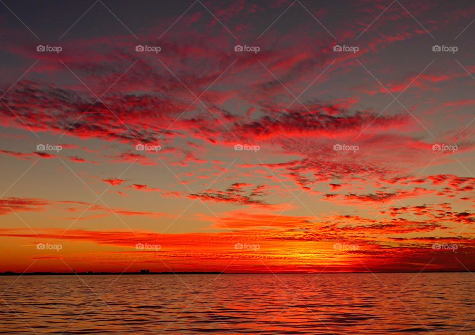 Red sky delight - red clouds floating over the shimmering bay like rows of soft pillows