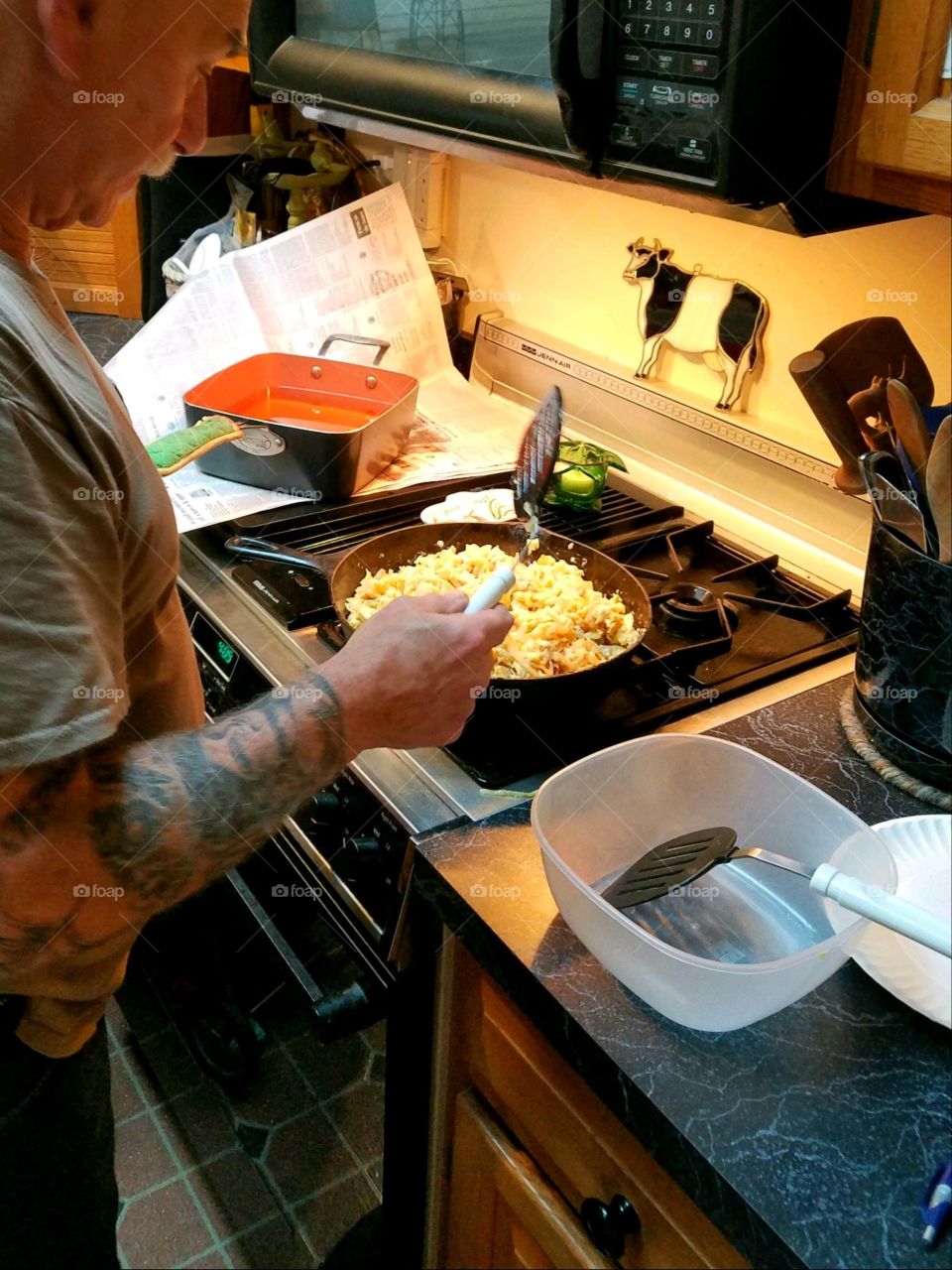 #stayathome - cooking at home. Making scrambled eggs for a brunch. Man cooking at the stove.