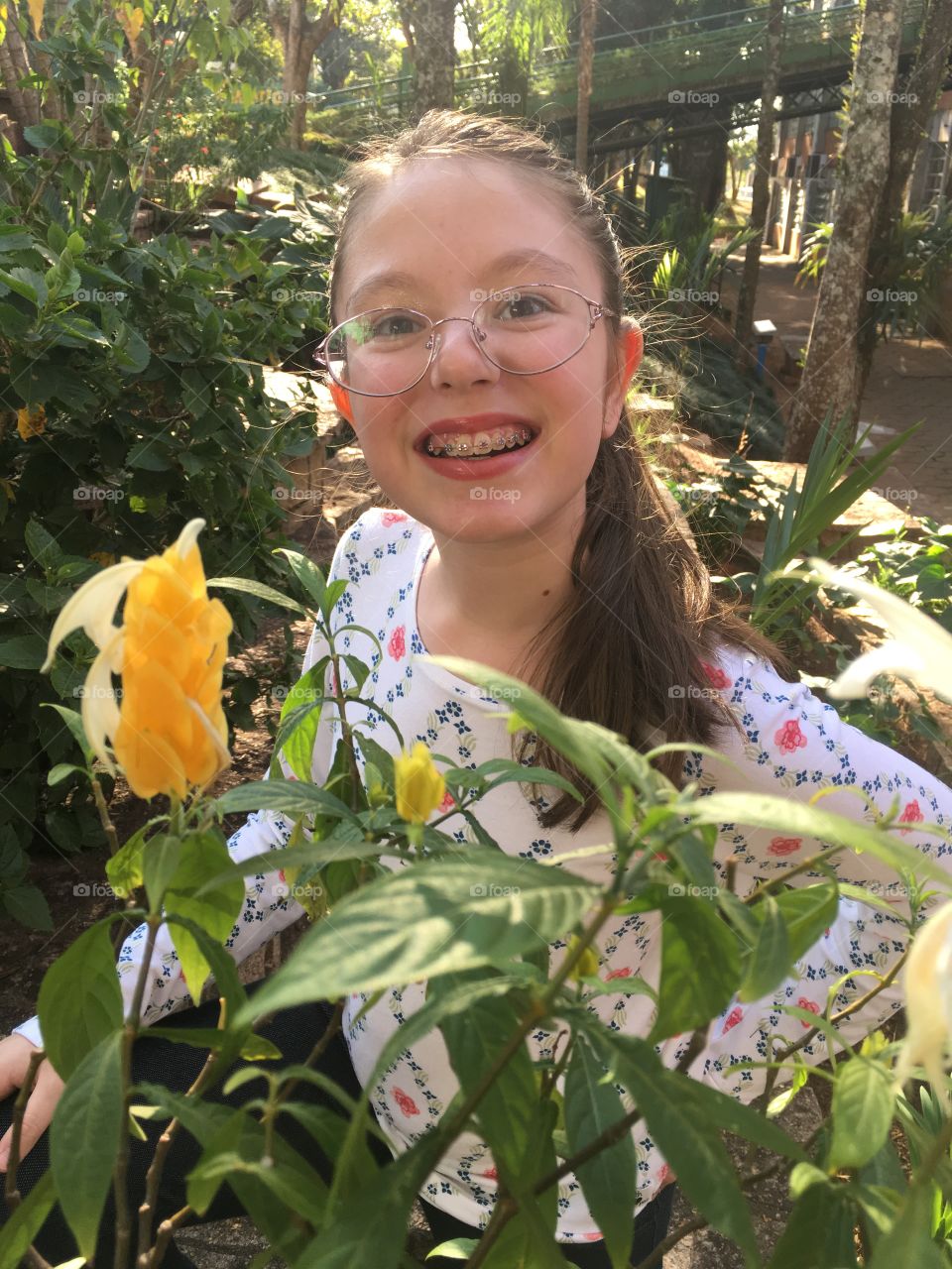 Minha doce filha Marina ao lado de uma belo botão desse camarão amarelo, uma típica flor tropical, no jardim da USF. 