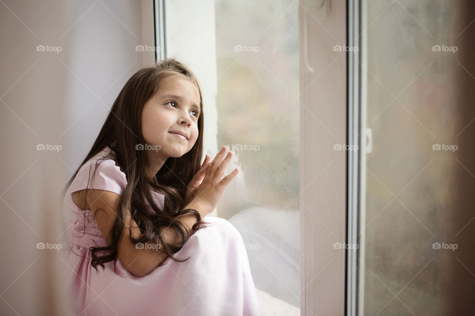 Pretty girl looking through window