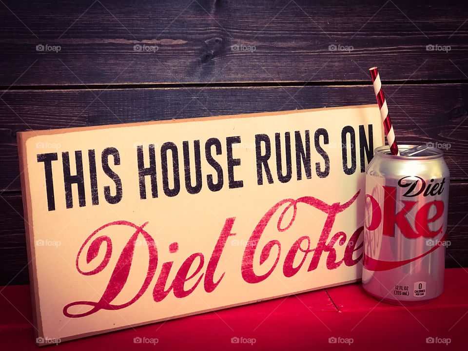 Diet Coke can with a drinking straw. Vintage Diet Coke sign with a wooden background. 