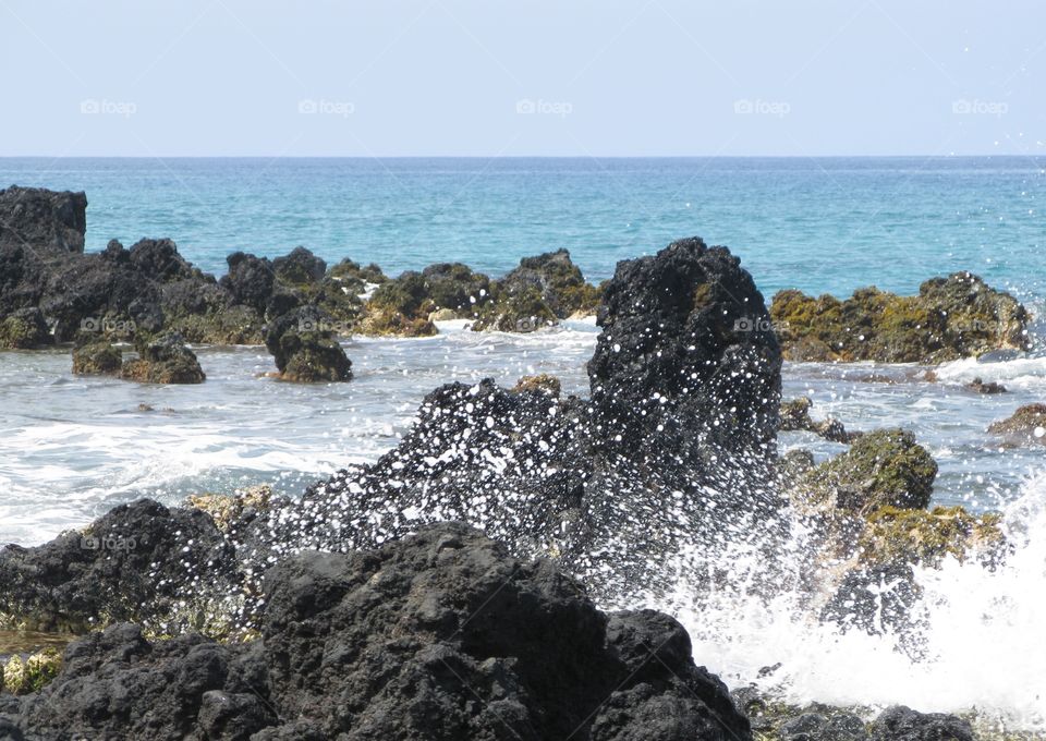 Waves splashing on lava rocks of Maui