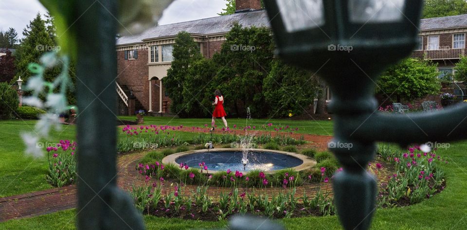 in a garden I spot a lovely lady in red walking across a path 