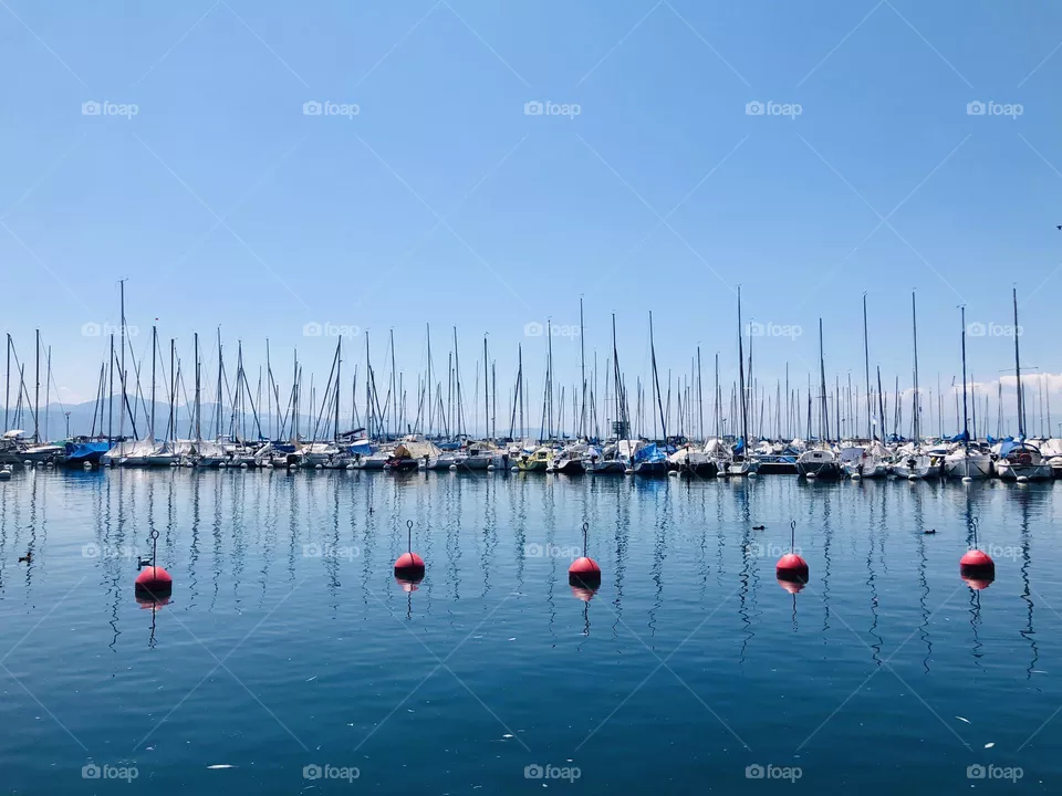 Moored boats and boat sails at Ouchy port in Lausanne, Switzerland, blue color palette 