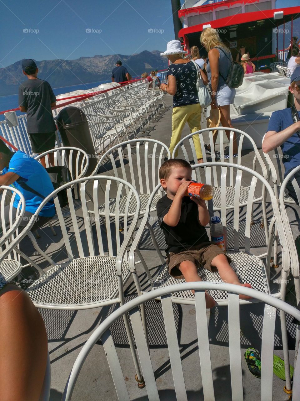 child drinking juice on boat