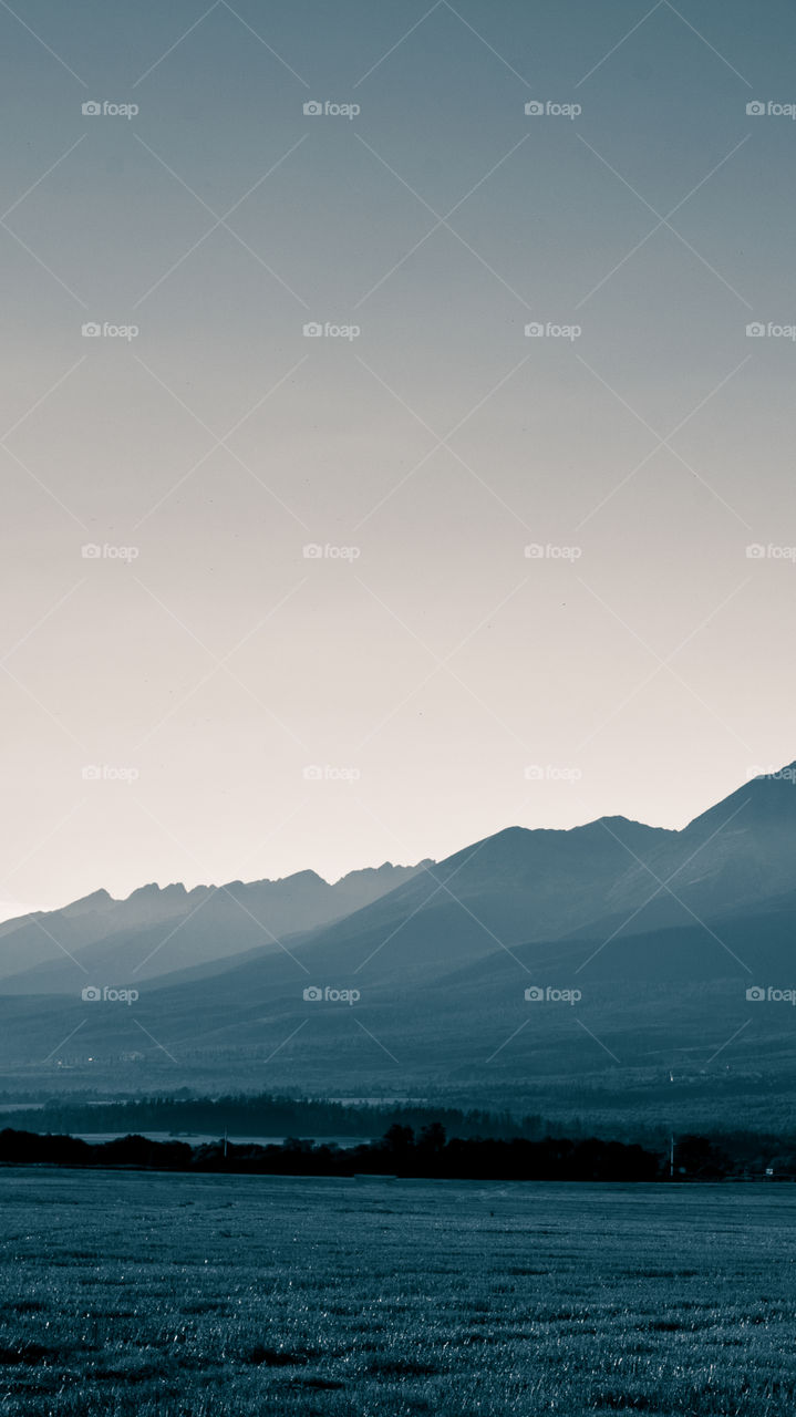 An inspiring mountain landscape. Tatry mountains in Slovakia. A beautiful wallpaper for smartphone screen. Monochrome blue abstract gradient with perspective.