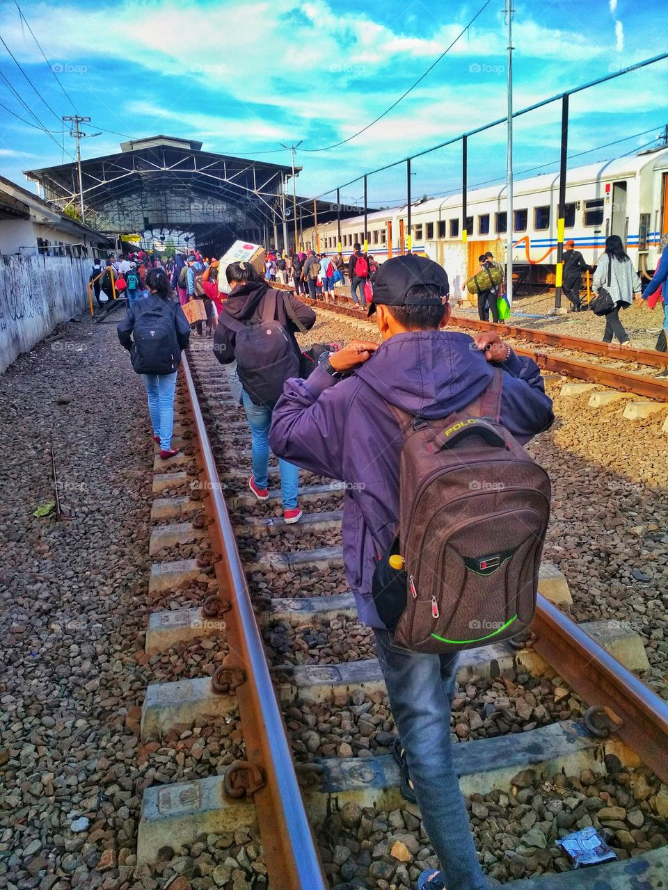 Train passengers walking on the tracks towards the exit