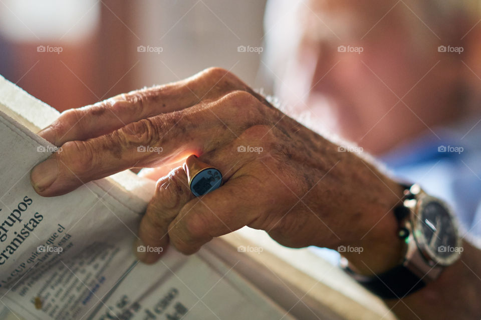 Elderly hand and newspaper