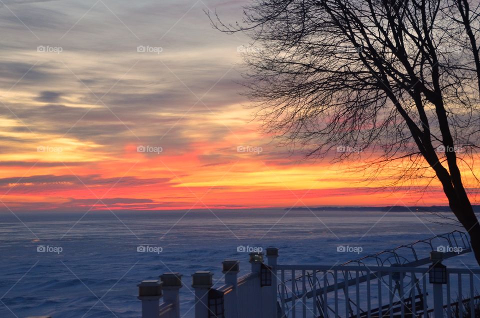 A winter sunrise over an ice covered lake. 