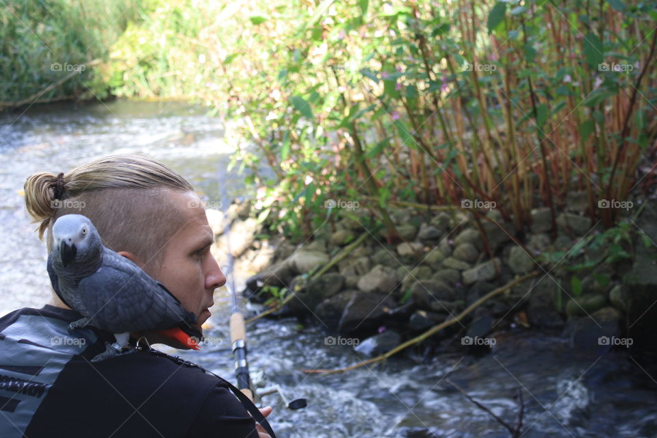 Gone fishin. Fishing in the river with my parrot