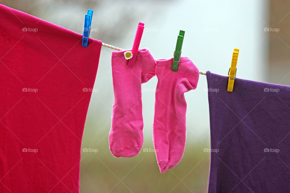 little pink socks and shirts on the clothes line rope