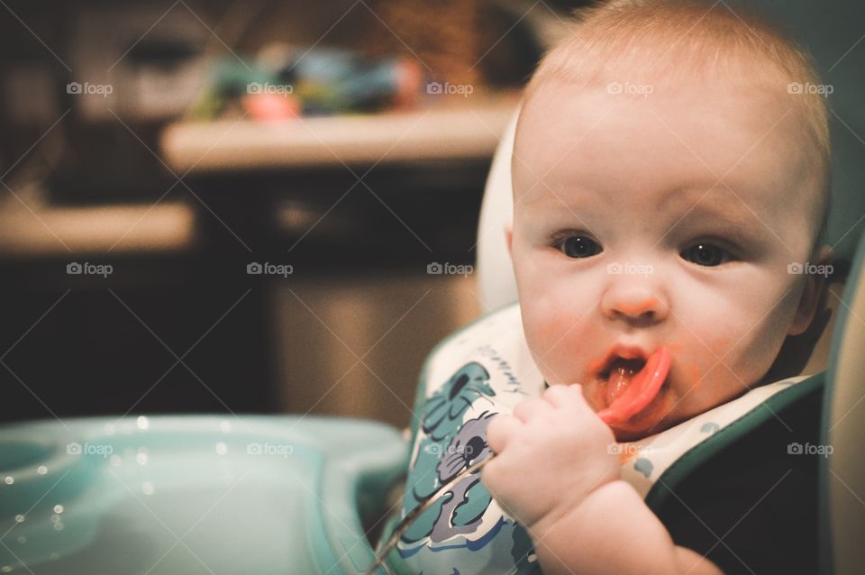 Infant son eating sweet potatoes and using a spoon for the first time!