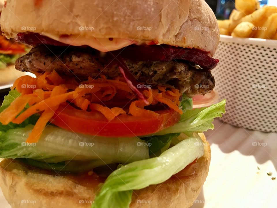Grilled chicken, beetroot, carrot, tomato and lettuce between two buns. It is so delightful !!