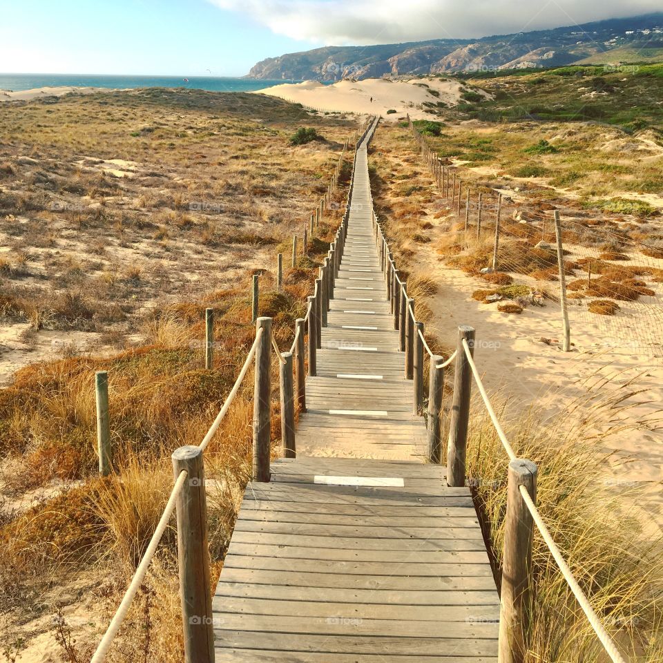 Wooden bridge leading to a sandy beach in Portugal 