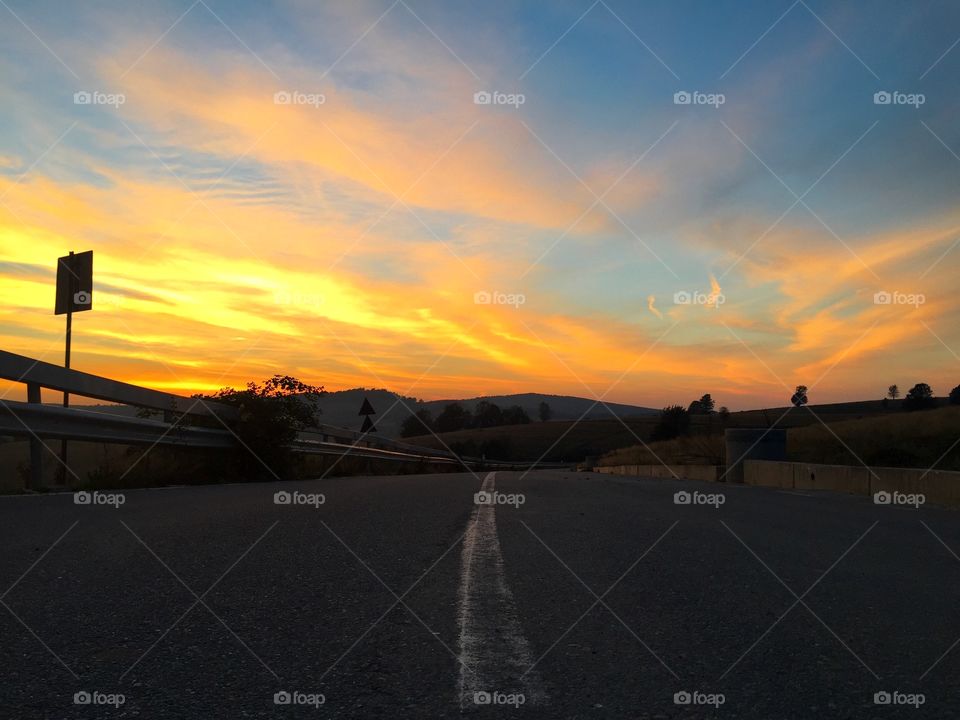 Empty road in the mountains at golden hour time