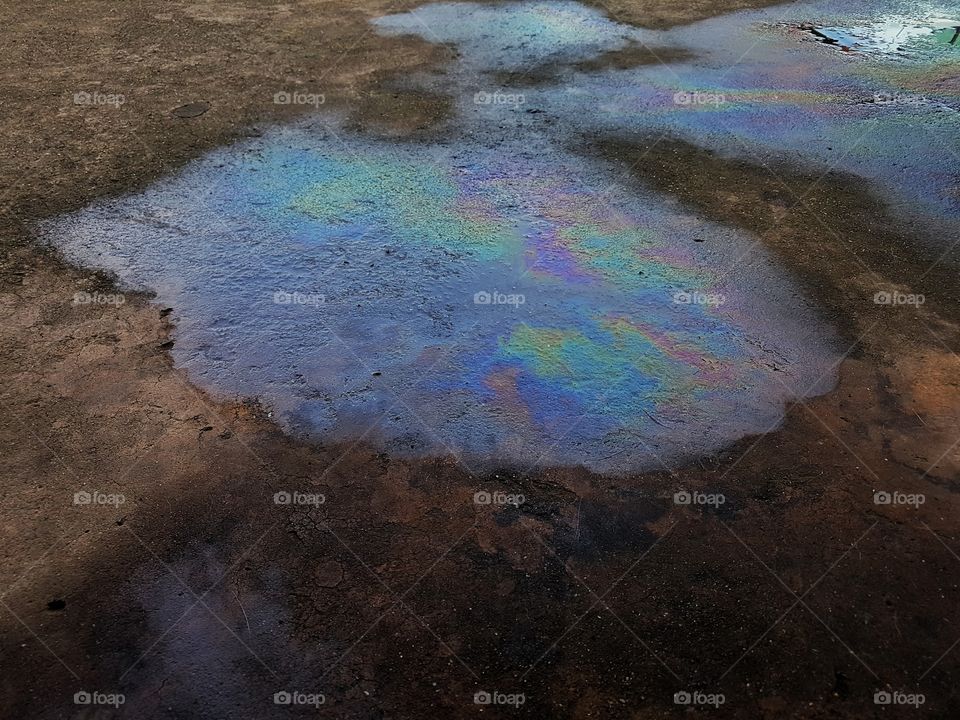 texture, multi colours reflection of a gasoline puddle on concrete floor