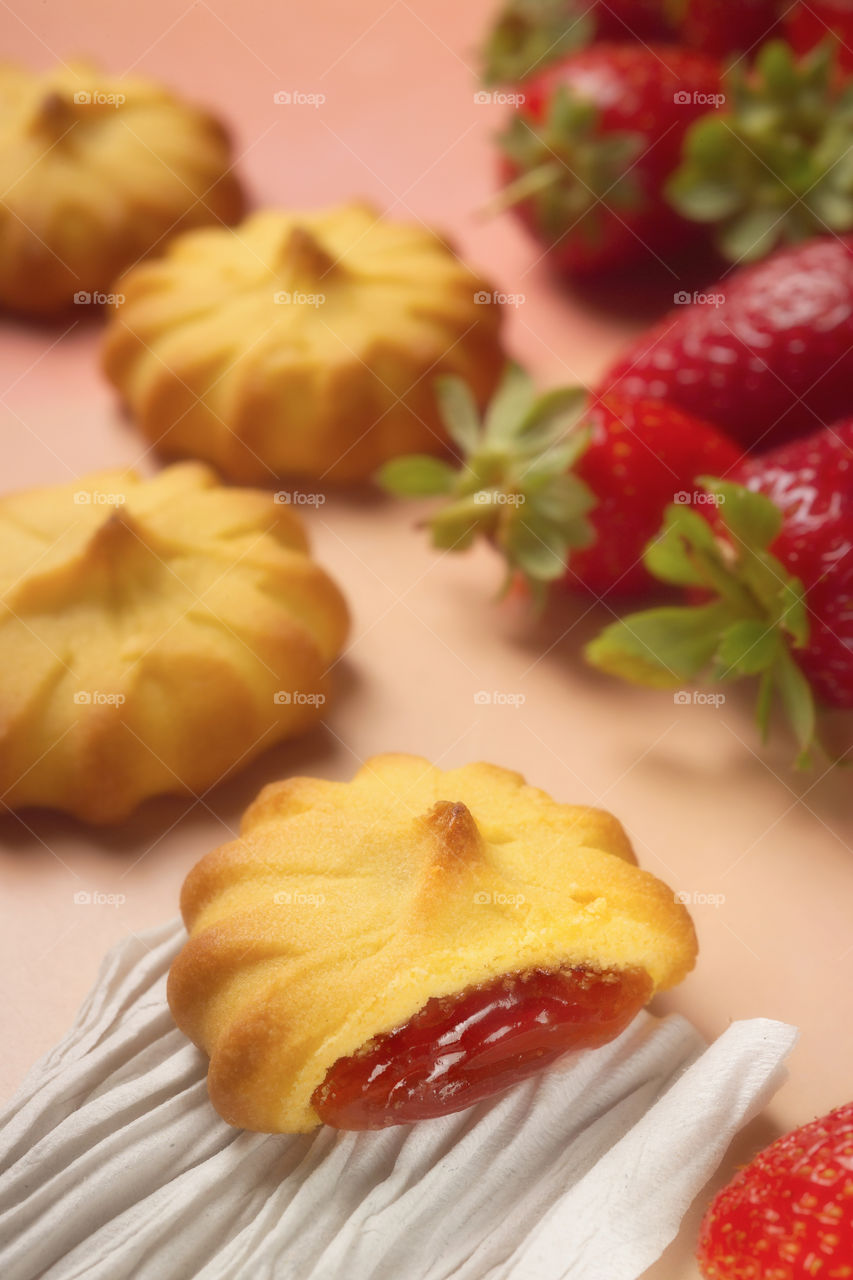 Closeup photo of strawberries and cookies filled with jar